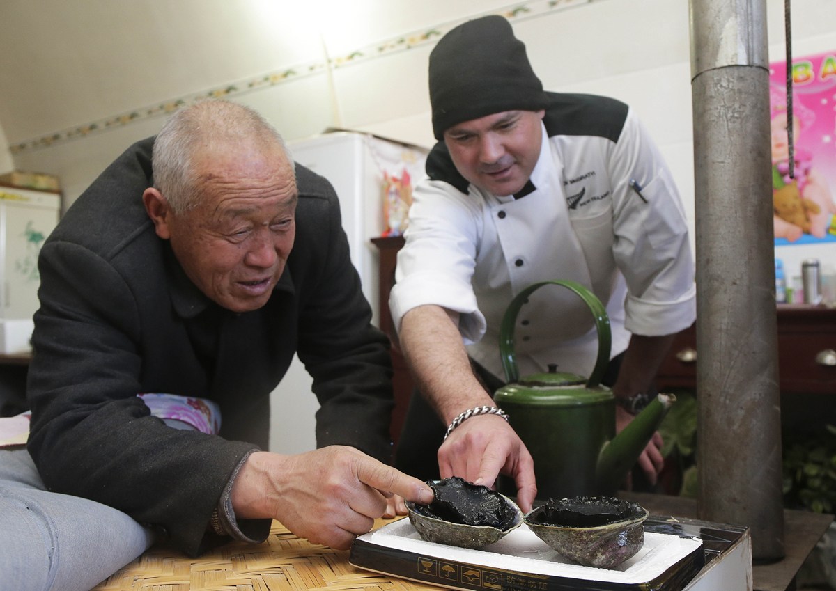 Zhang Fucai inspects the NZ abalone with chef Dion McGrath